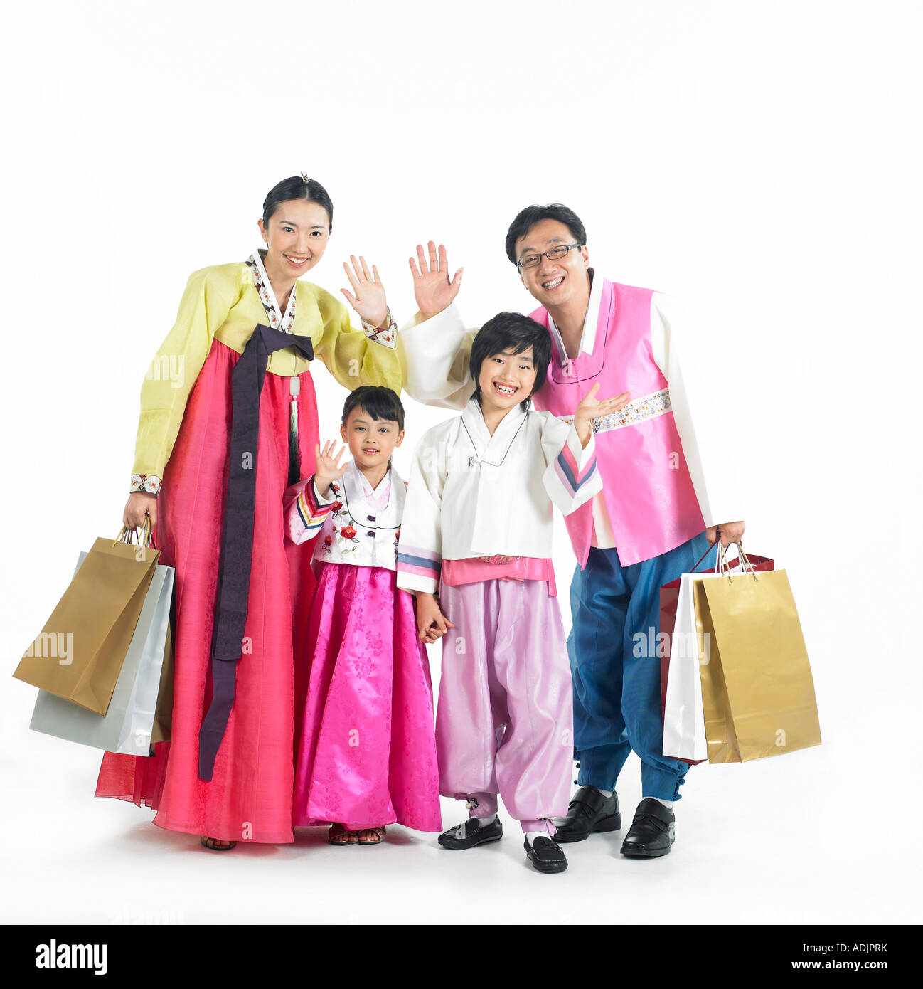 Una famiglia coreana indossando Hanboek sta tenendo le mani in alto con un sorriso Foto Stock