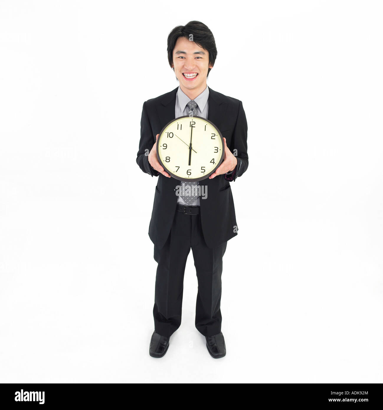 Un imprenditore tenendo un orologio Foto Stock