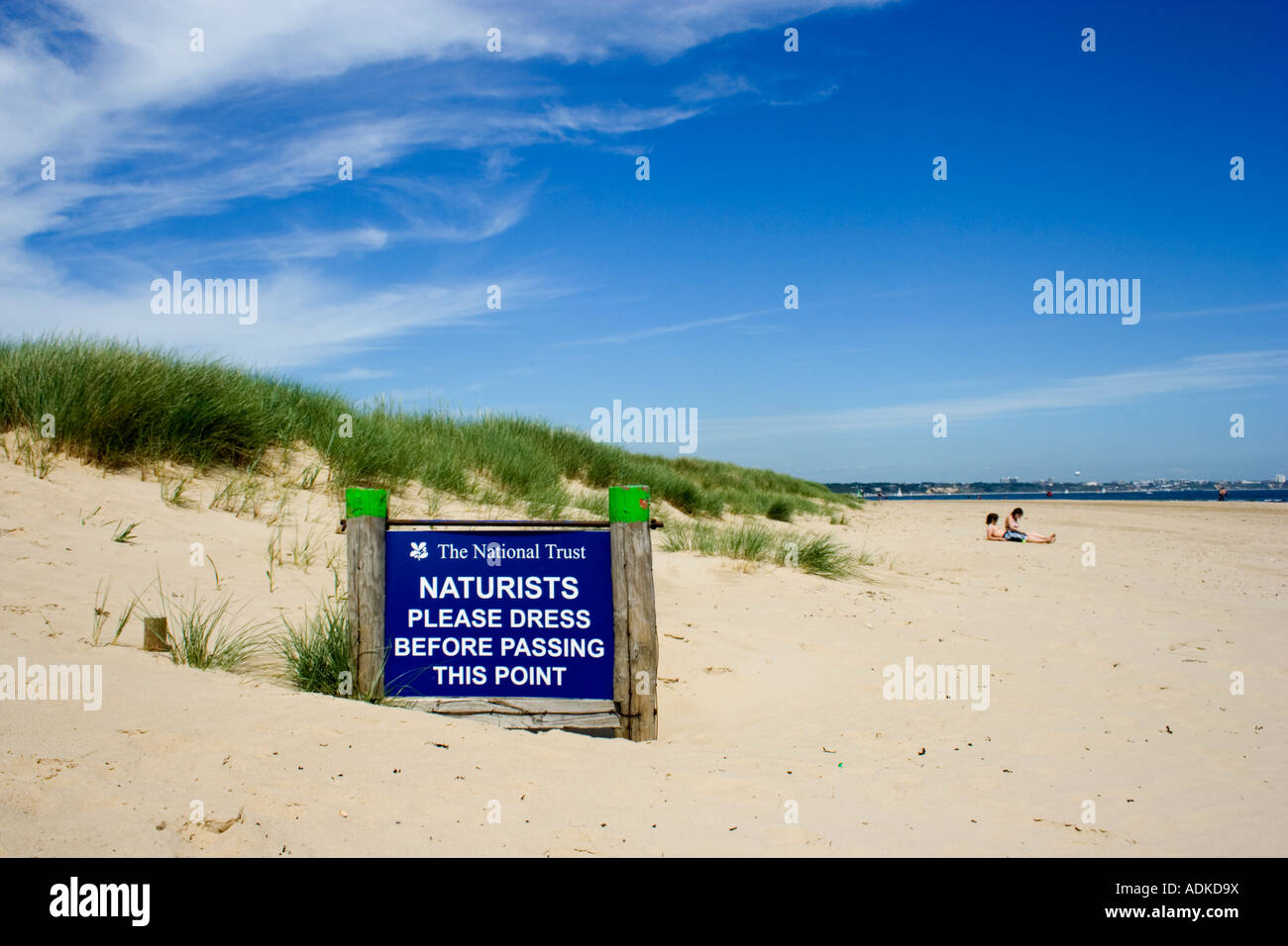 Naturisti segno sulla spiaggia sabbiosa a Studland, Isle of Purbeck, Dorset, Regno Unito Foto Stock