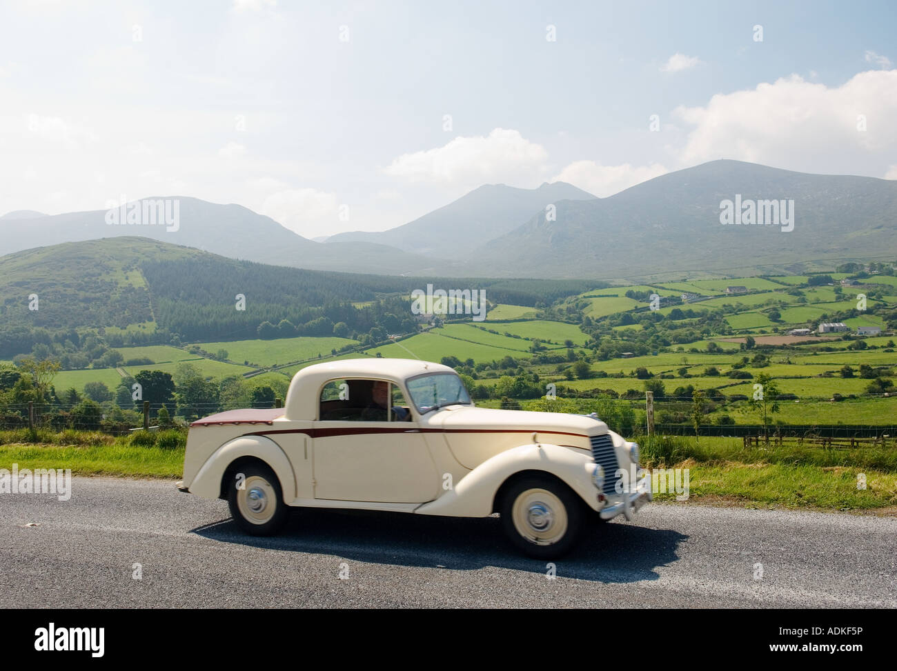 Auto d'epoca tourer sulla strada Trassey attraverso la Mourne Mountains, County Down, Irlanda con Slieve Bearnagh nella distanza. Foto Stock