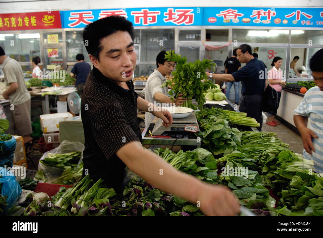Un venditore mettere le verdure in ordine in un mercato alimentare a Beijing in Cina 13 Ago 2007 Foto Stock