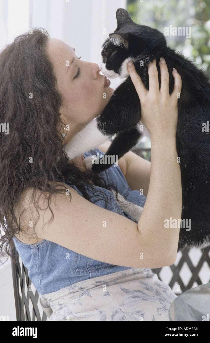 Vista laterale della donna kissing gatto nero Foto Stock