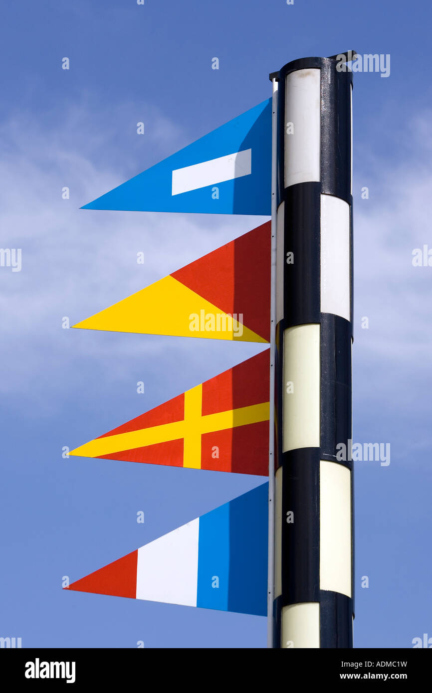 Colorato segnale nautiche bandiere sul polo blu cielo dietro il Port Vell Barcellona Catalonia Spagna Foto Stock