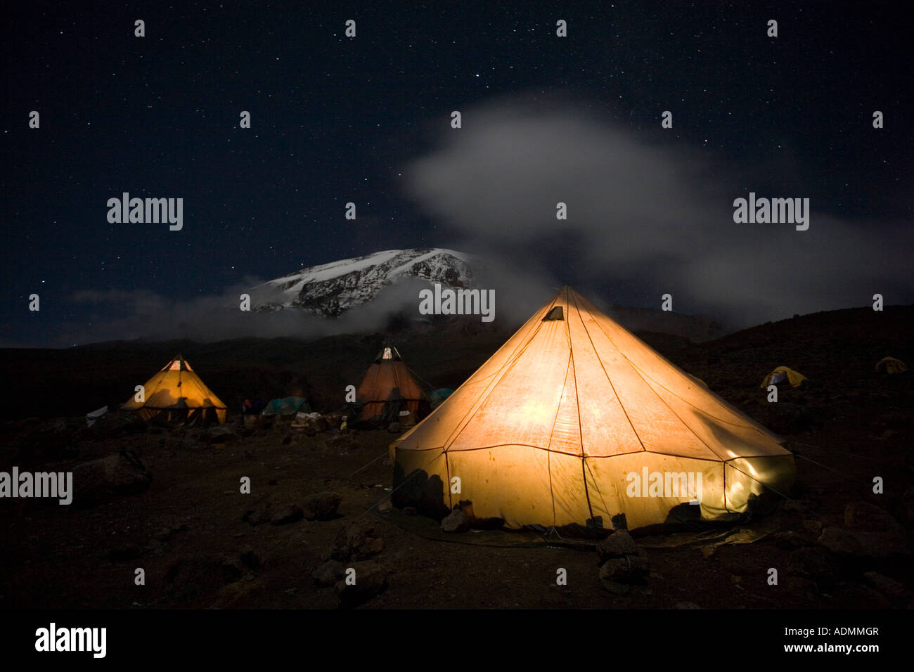 Africa Tanzania Parco Nazionale del Kilimanjaro Signor Arrampicata parti tende glow contro il cielo notturno a Karanga Camp Foto Stock