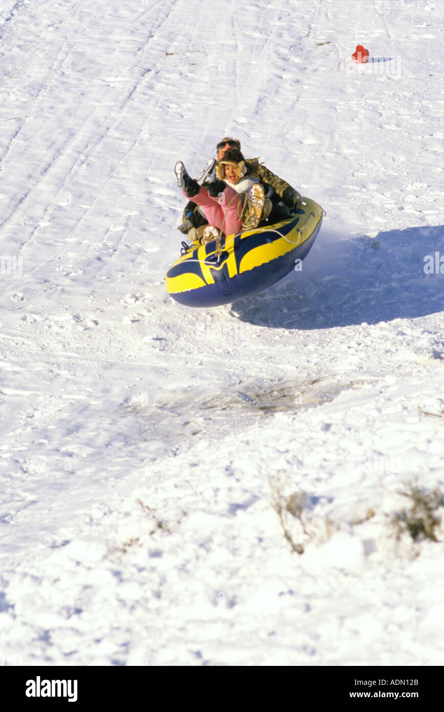 Persone slittino nella neve su una zattera gonfiabile Foto stock