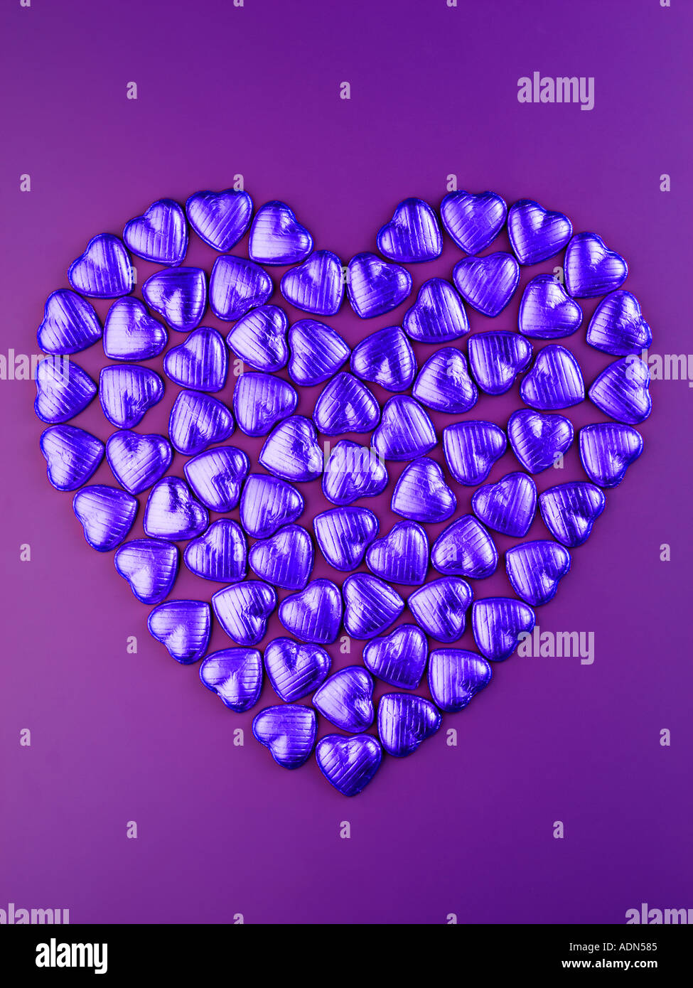 Blu cuore di cioccolato su viola Foto Stock