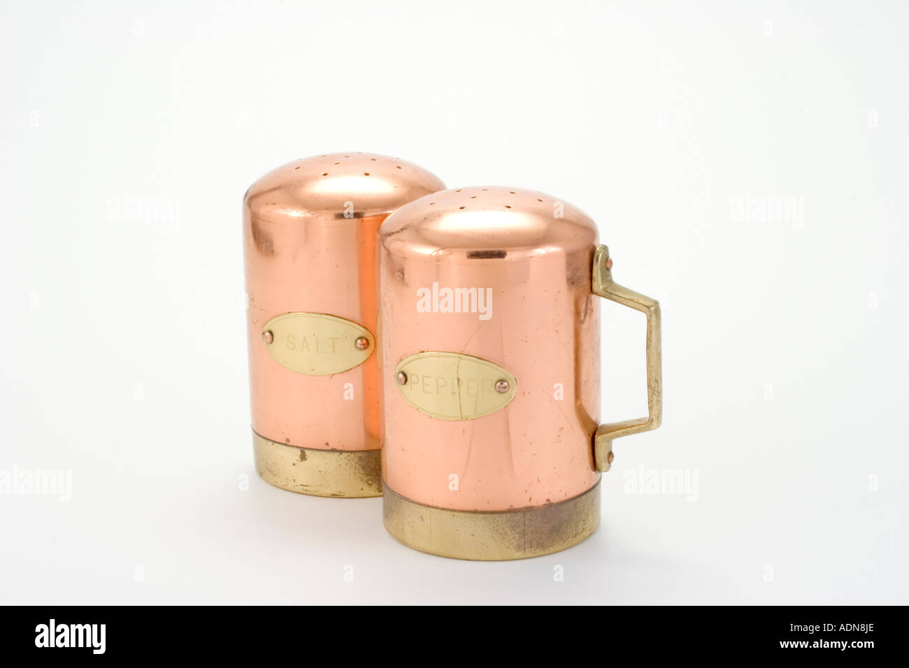 Rame decorativo sale e pepe tabella shakers su sfondo bianco Foto Stock