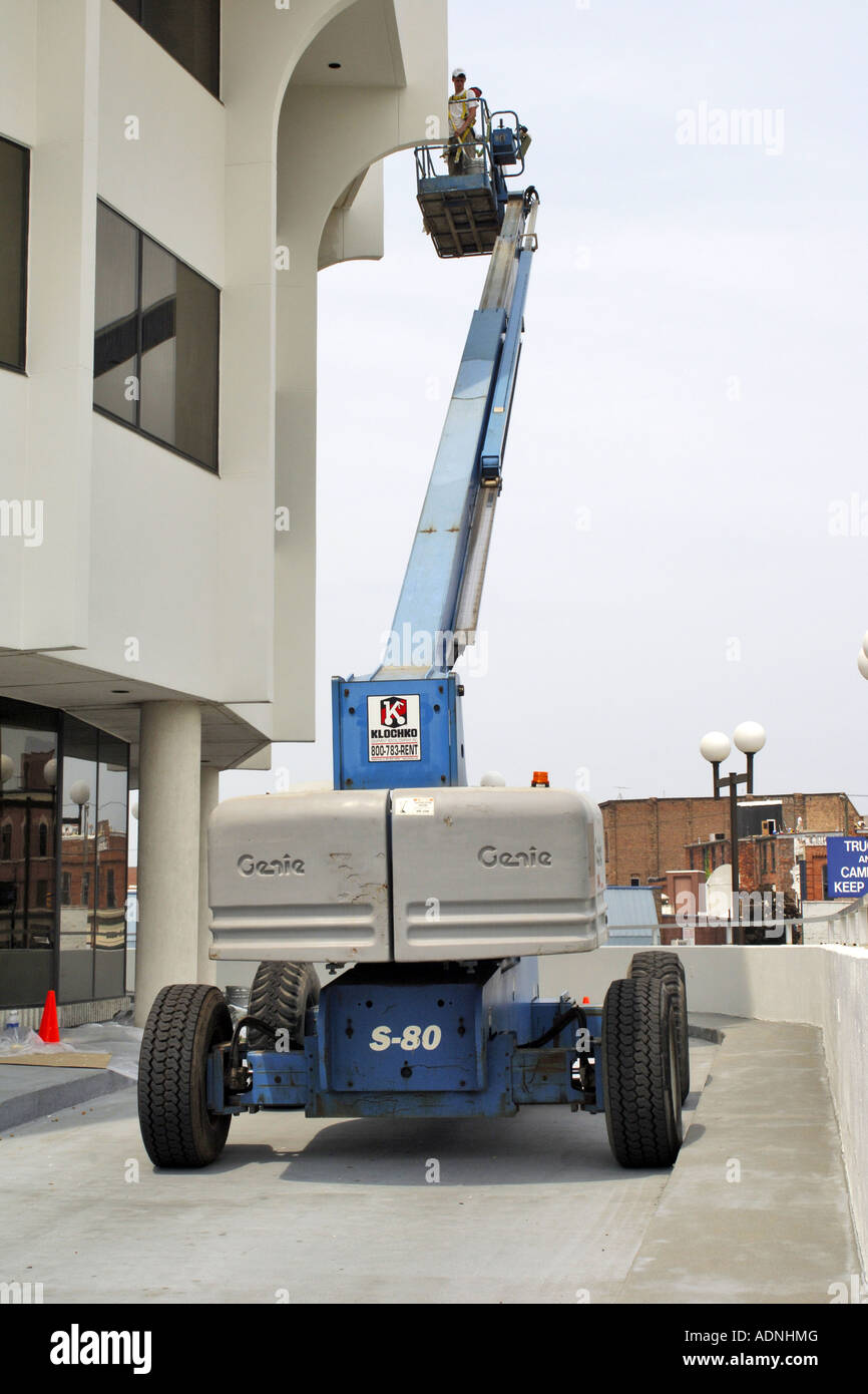 Pittori utilizzando un sollevatore hydrolic mentre la verniciatura di un edificio bianco nel centro cittadino di Port Huron Foto Stock