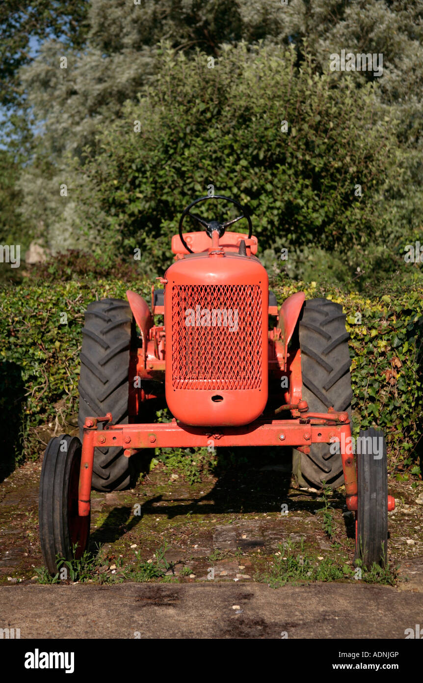 Vecchio trattore agricolo rosso all'aperto in giardino Foto Stock