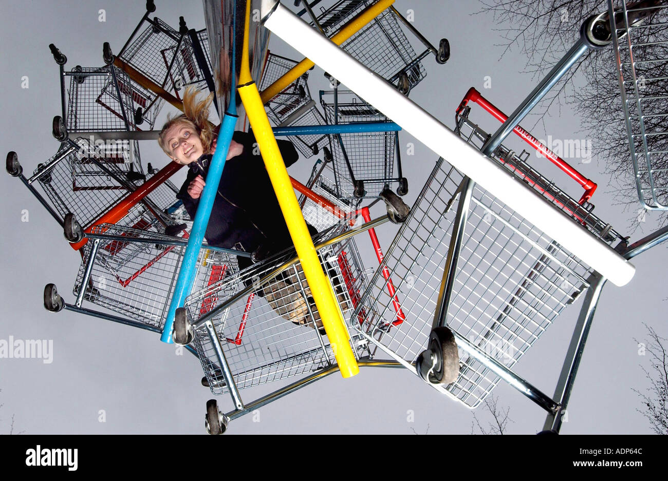 Attraente donna bionda sorridente da una torre di 22 supermercato carrelli di shopping Foto Stock Attraente donna bionda sorridente da una torre di 22 supermercato carrelli di shopping Foto Stock