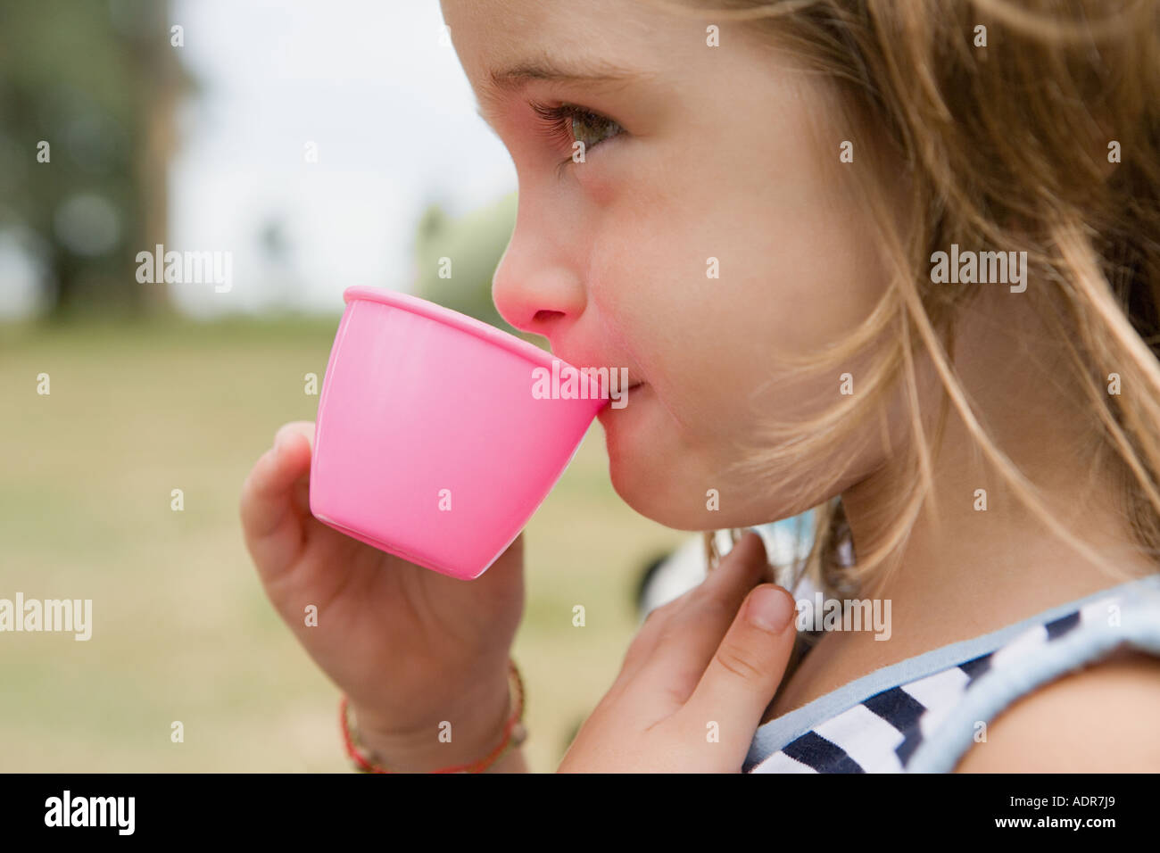 Ragazza di bere da un bicchiere di plastica Foto Stock