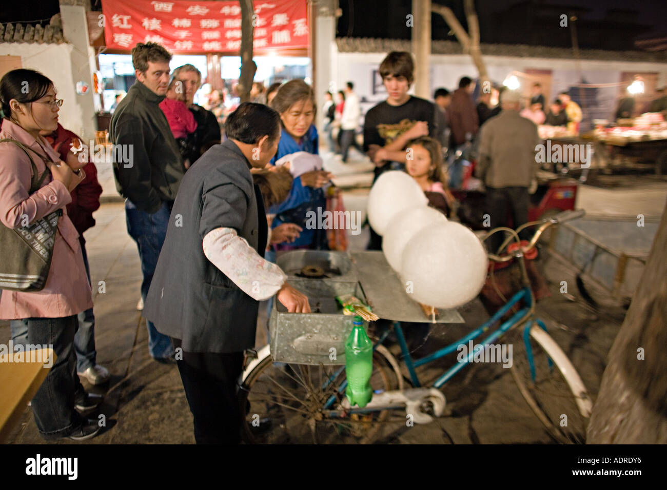 Cina Xi'an scena notturna del fornitore di biciclette la realizzazione e la vendita dello zucchero filato Candy di cotone Foto Stock