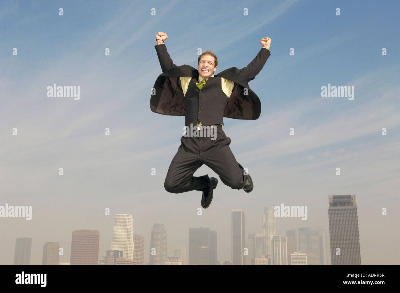 Uomo di affari pugni di pompaggio mid-aria sopra di città Foto Stock