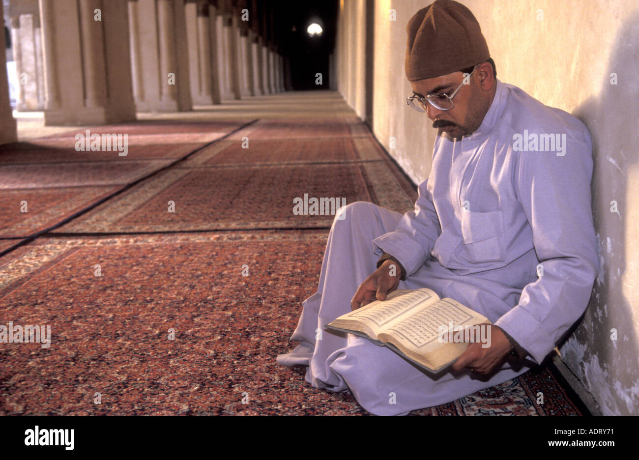 L Imam leggere il Corano in un corridoio di Ibn Tulun moschea in Il Cairo Egitto Foto Stock