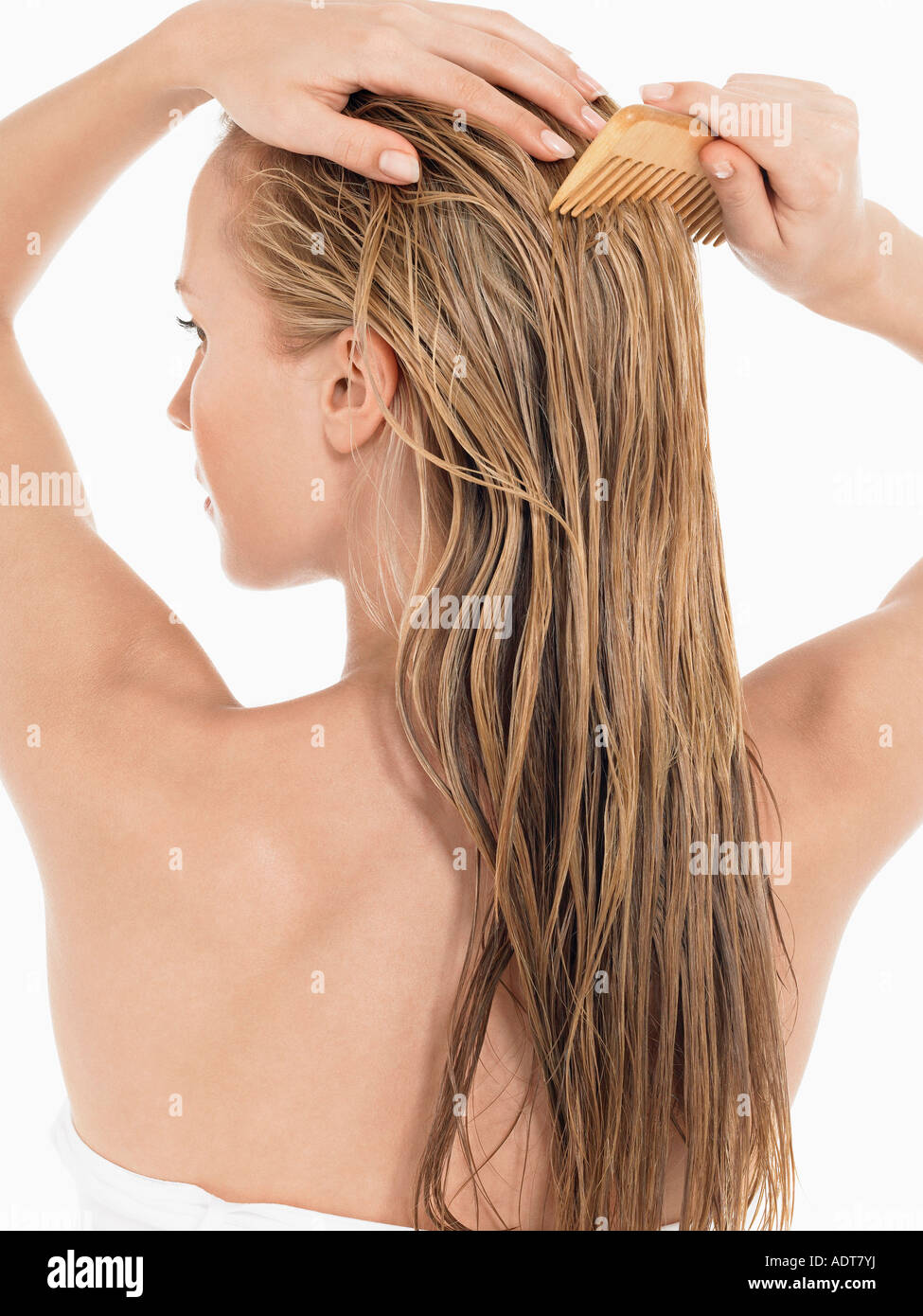 Giovane donna bionda di pettinatura dei capelli bagnati, vista posteriore Foto Stock