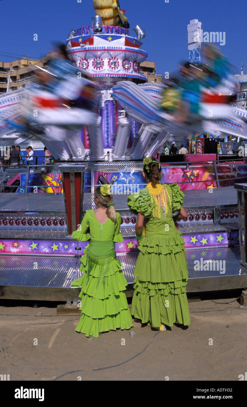 Sanlucar de Barrameda due donne in abito di flamenco guardando un divertente attrazione equo Foto Stock
