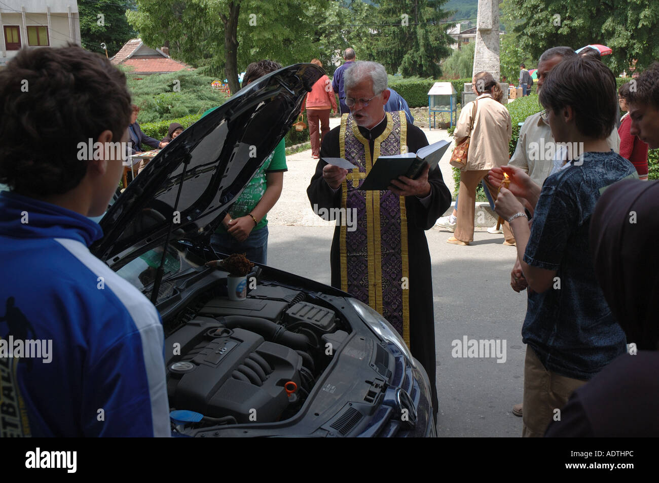 Un sacerdote benedice una VW Automobile in Romania, portando un significato tutto nuovo per la frase ' tenendo la macchina in per un servizio'. Foto Stock