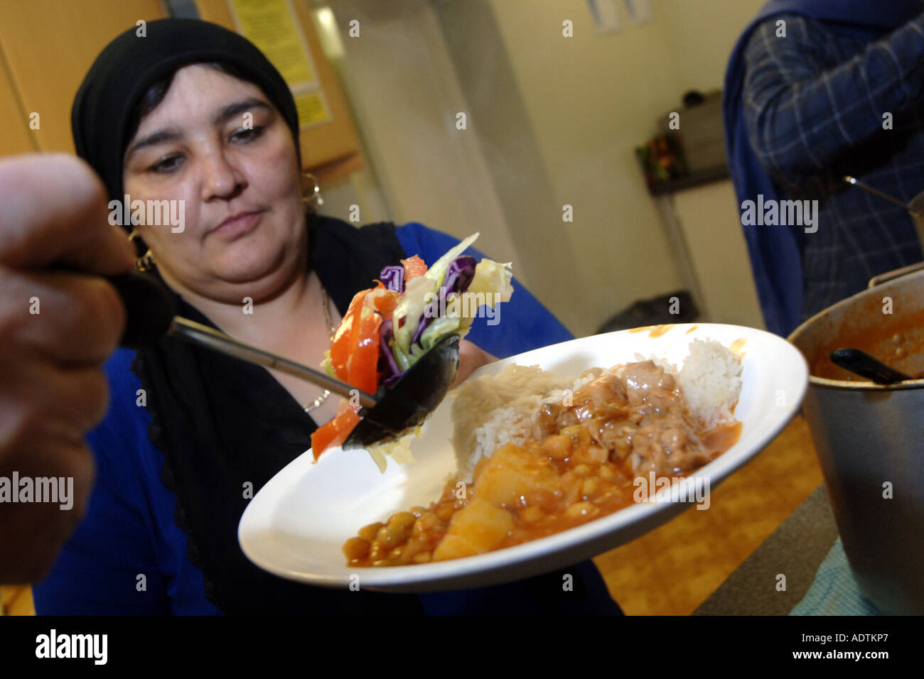 I volontari prestano il loro servizio curry per rifugiati e richiedenti asilo in una zuppa di cucina presso una sala della chiesa Bradford West Yorkshire Foto Stock