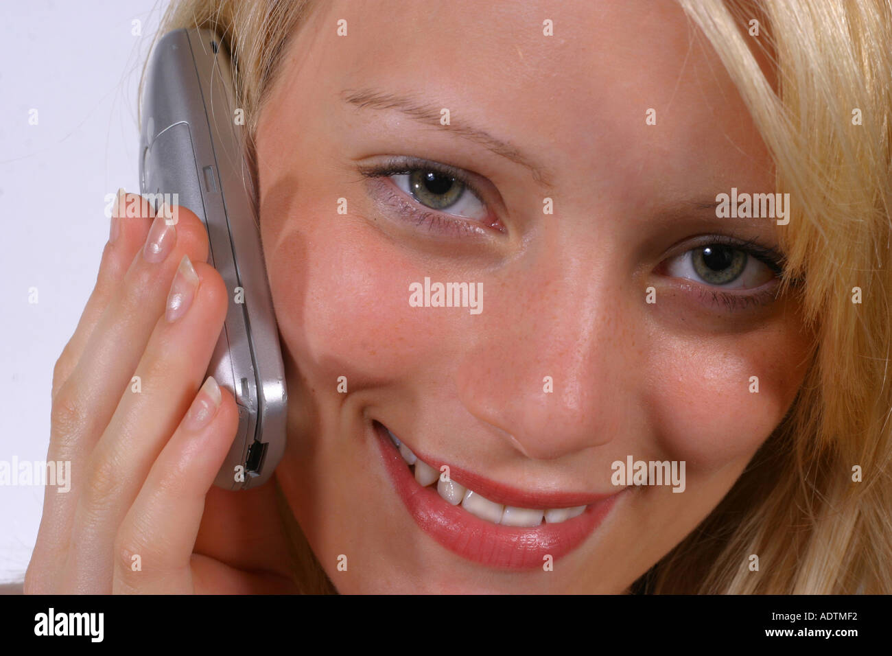 Giovane ragazza sorridente su un telefono cellulare Foto Stock