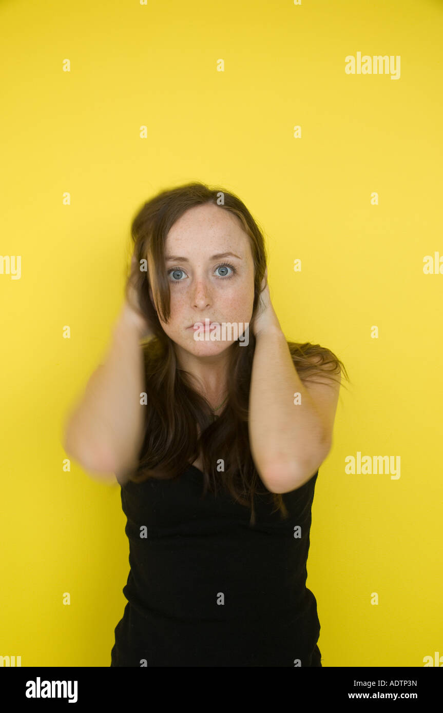 Un sottolineato preoccupato interessati dai capelli rossi freckled fronte donna giovane studente con sfondo giallo Foto Stock