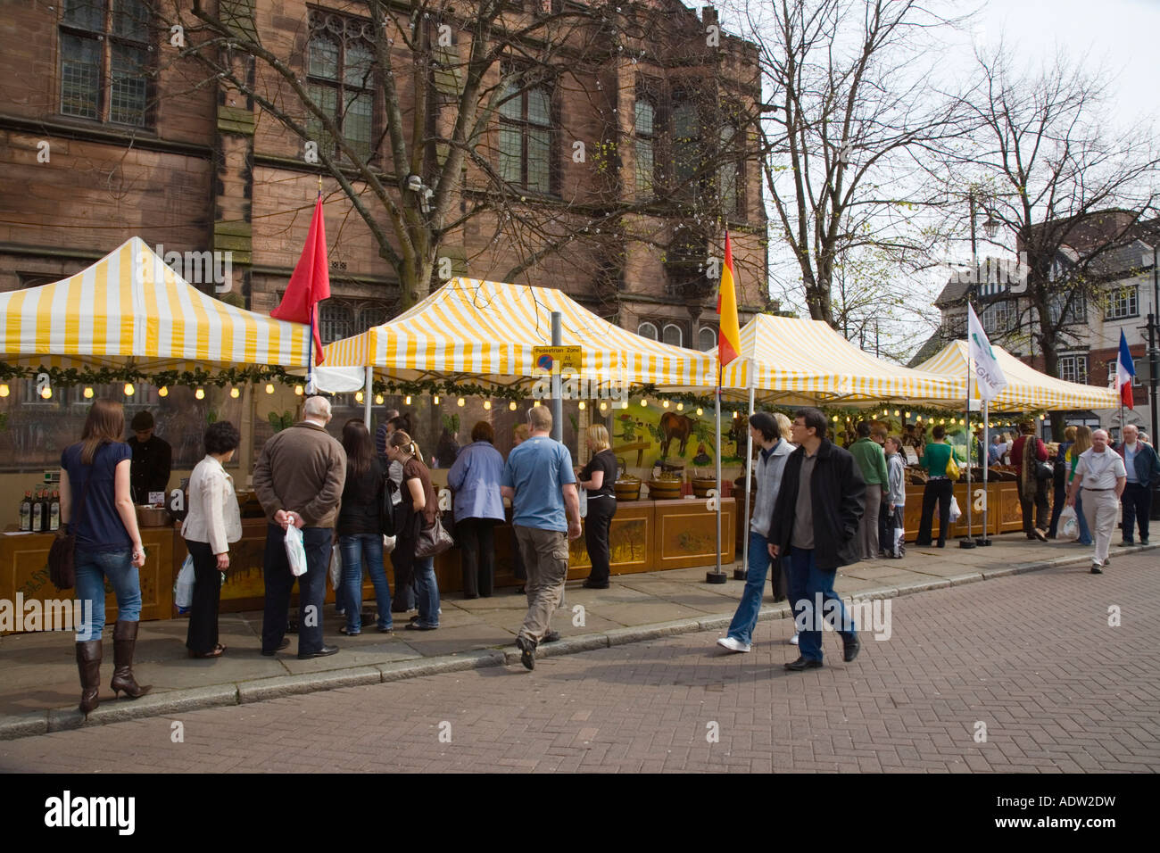 Il francese le bancarelle del mercato sotto bianco giallo tettoie vendita di vari prodotti occupato con people shopping Chester Cheshire England Regno Unito Foto Stock