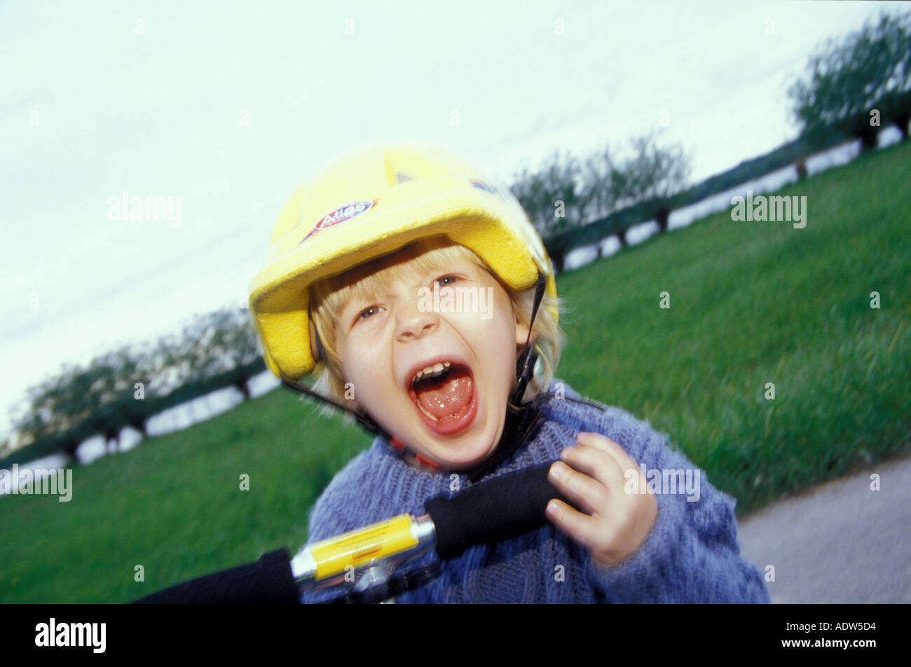 Ragazzo (3-5) nel ciclismo casco urlando, close-up Foto Stock