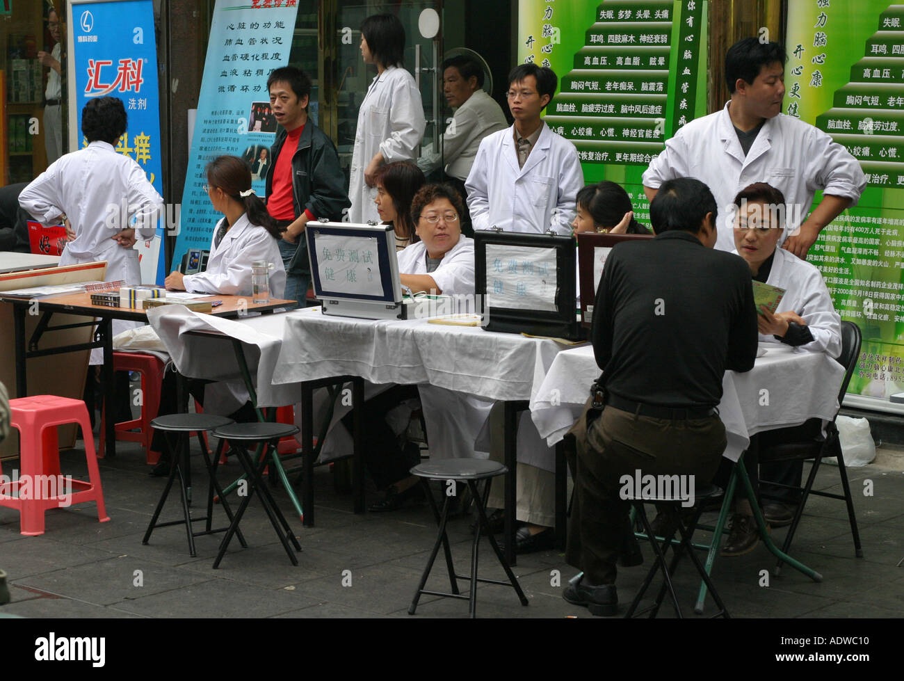 I medici distribuiscono i tradizionali a base di erbe della medicina cinese da una bancarella di strada a Beijing in Cina per il passaggio di persone locali e turisti Foto Stock