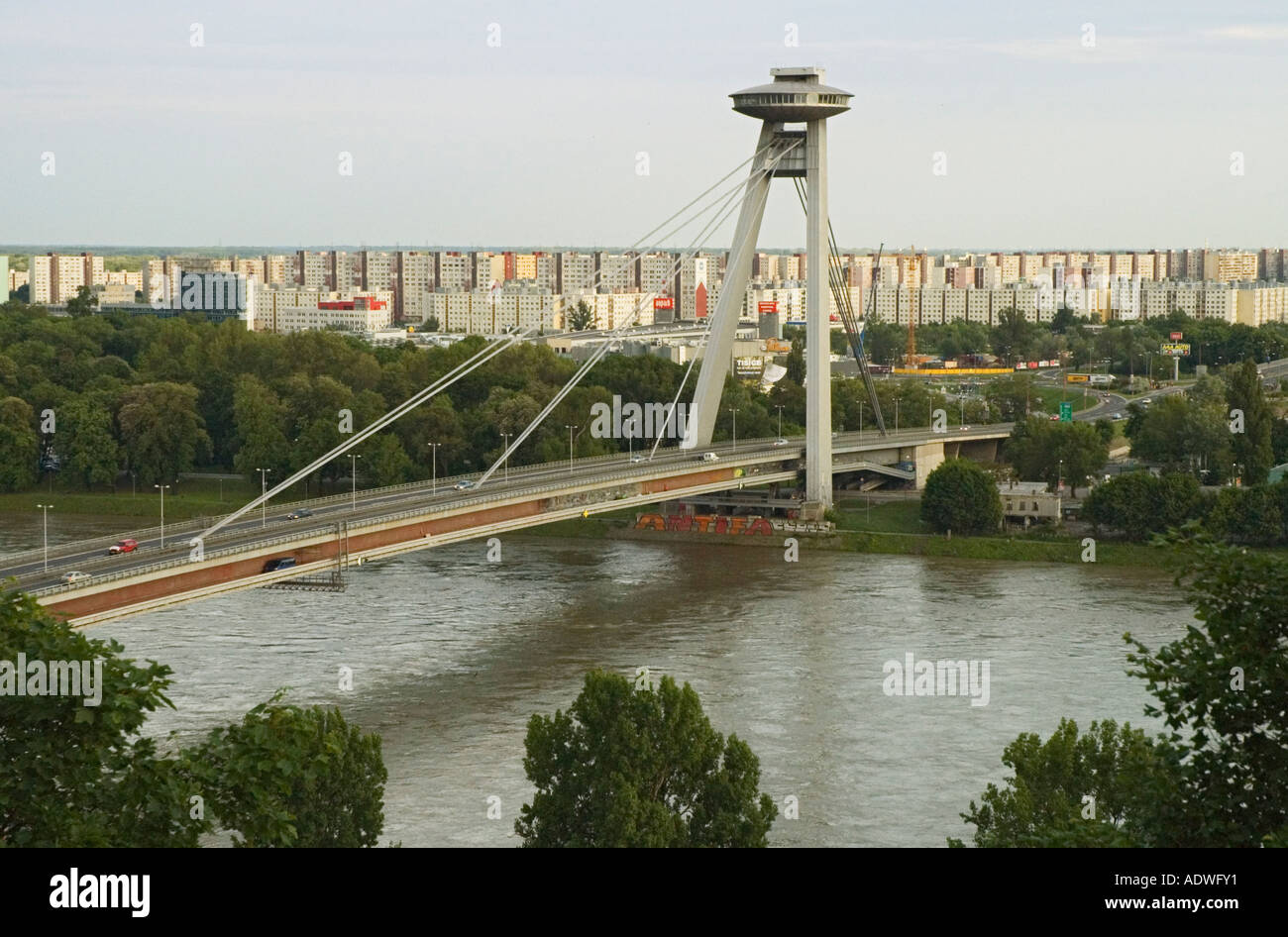 Repubblica Slovacca Bratislava vista dal castello verso il nuovo ponte sul fiume Danubio era comunista blocchi di appartamenti in distanza Foto Stock