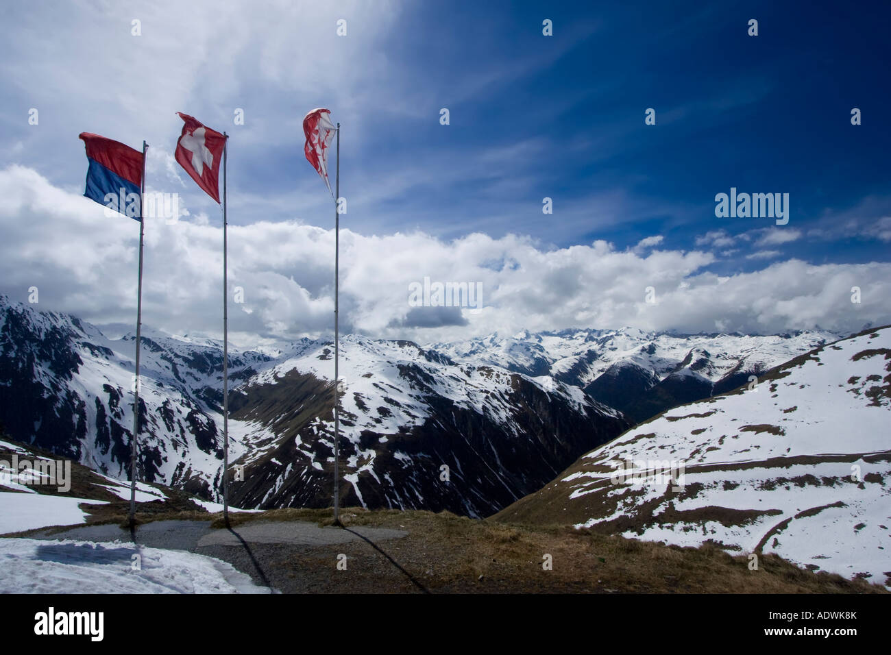 Bandiere flottante del Ticino, Svizzera e Wallis nel vento sul Nufenenpass, Svizzera Foto Stock