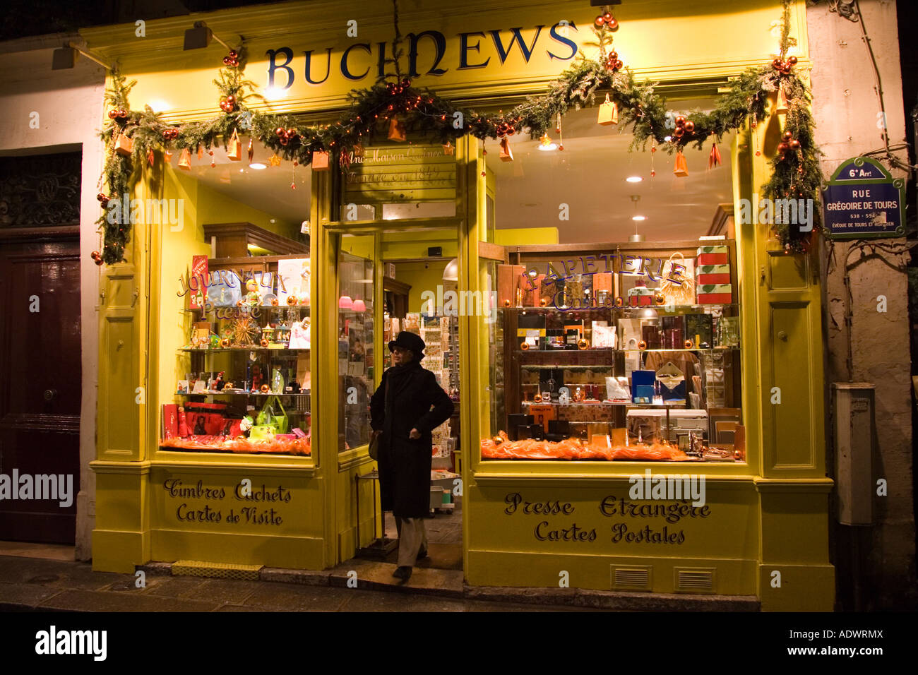 Donna lascia un parigino edicola Negozio in Rue Gregoire de Tours Parigi Francia Foto Stock