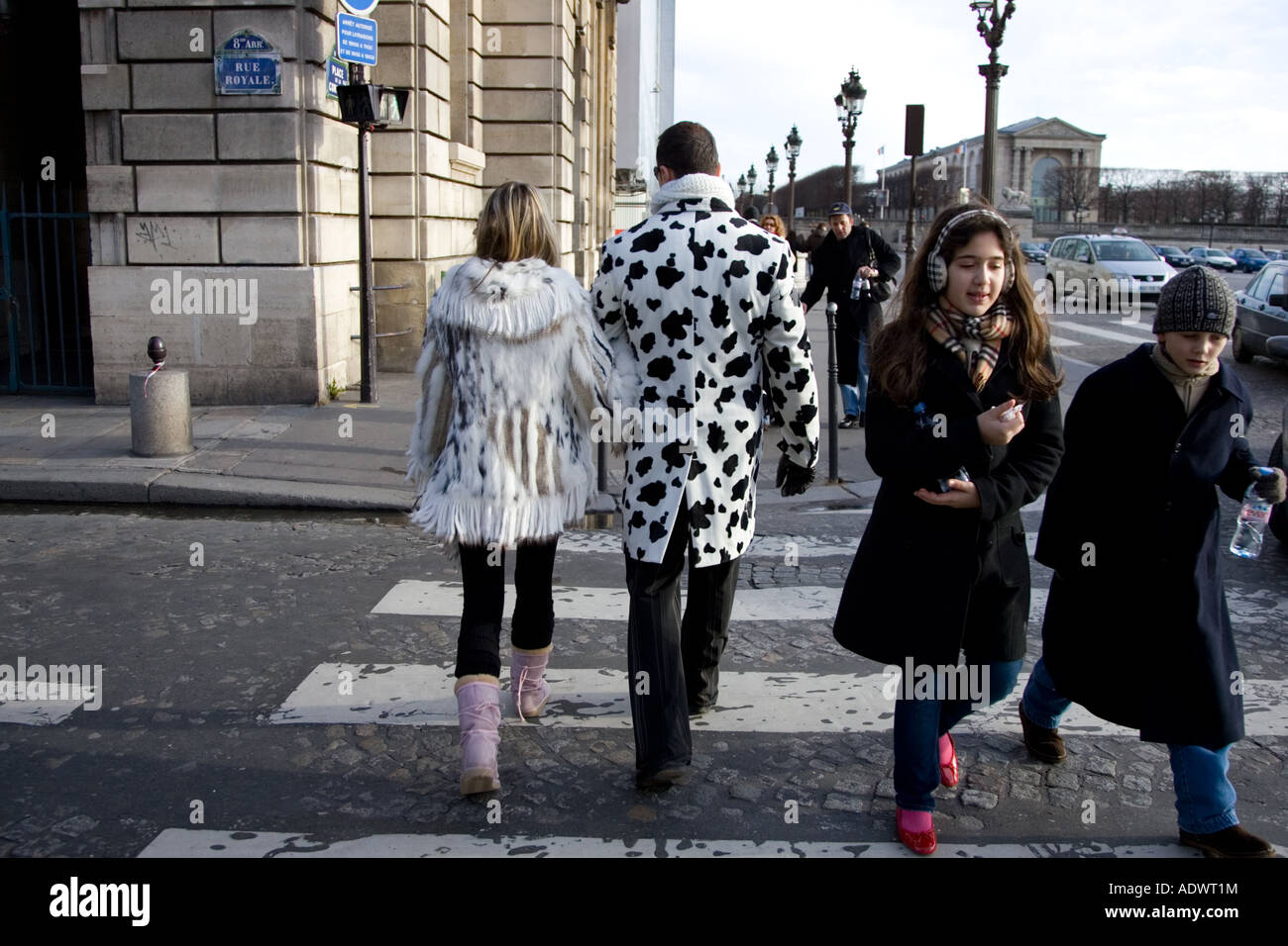 Pedoni in cappotti invernali camminare sul lastricato della strada sulle strisce pedonali in Place de la Concorde centrale di Parigi Francia Foto Stock