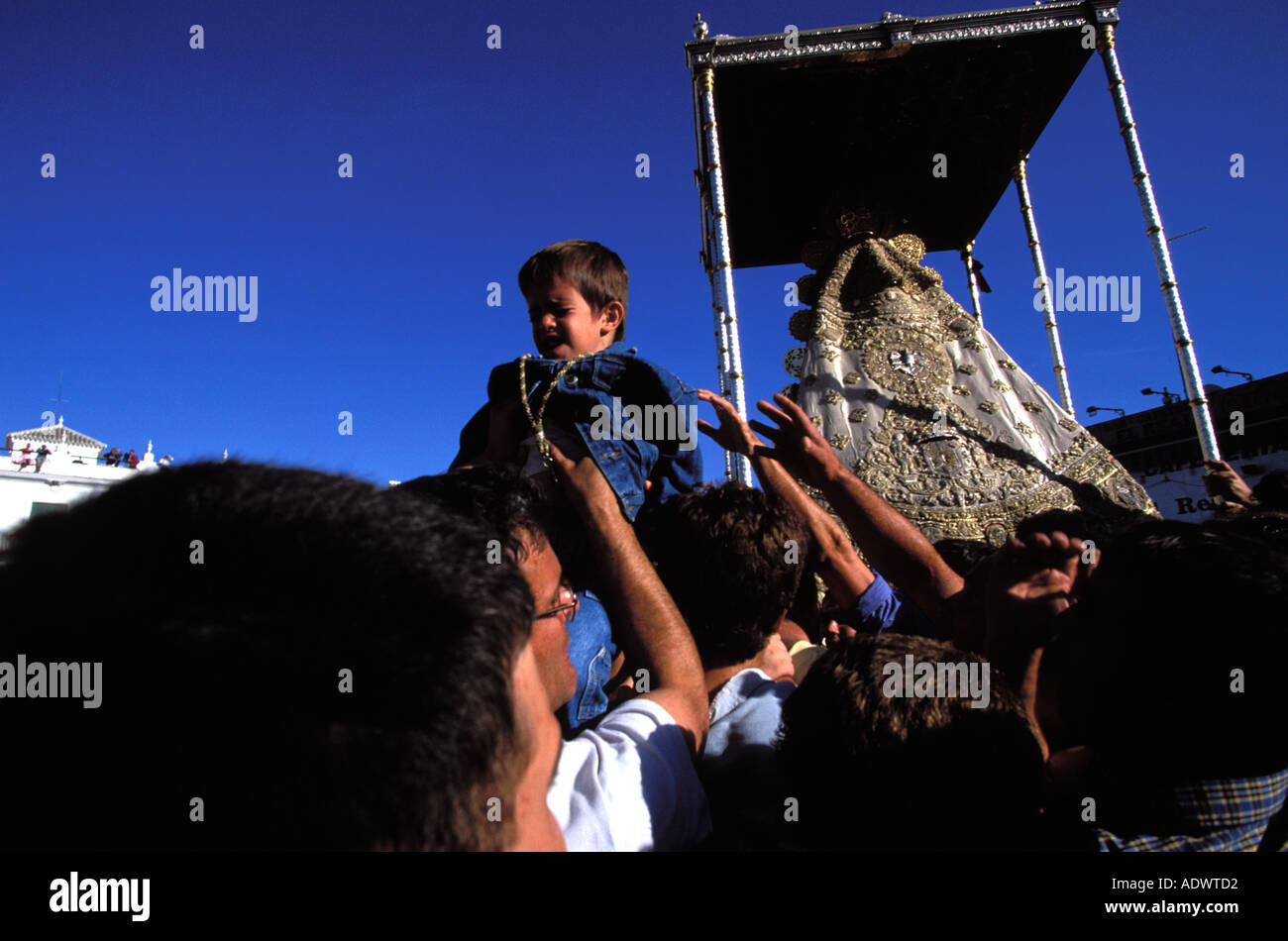 El Rocio un ragazzo è portato sopra la folla a toccare la Paloma Blanca Foto Stock