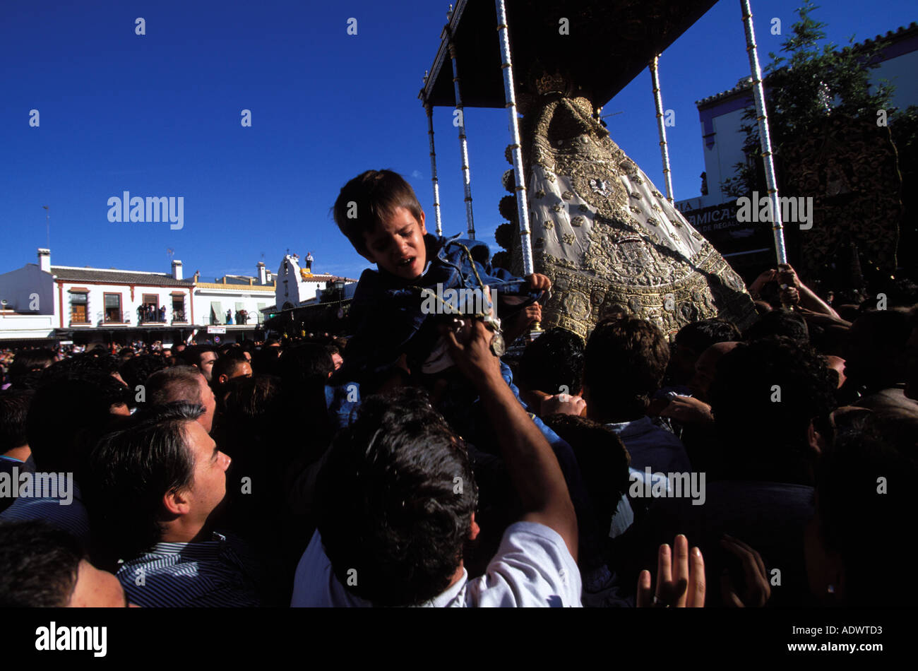 El Rocio un ragazzo è portato sopra la folla a toccare la Paloma Blanca Foto Stock