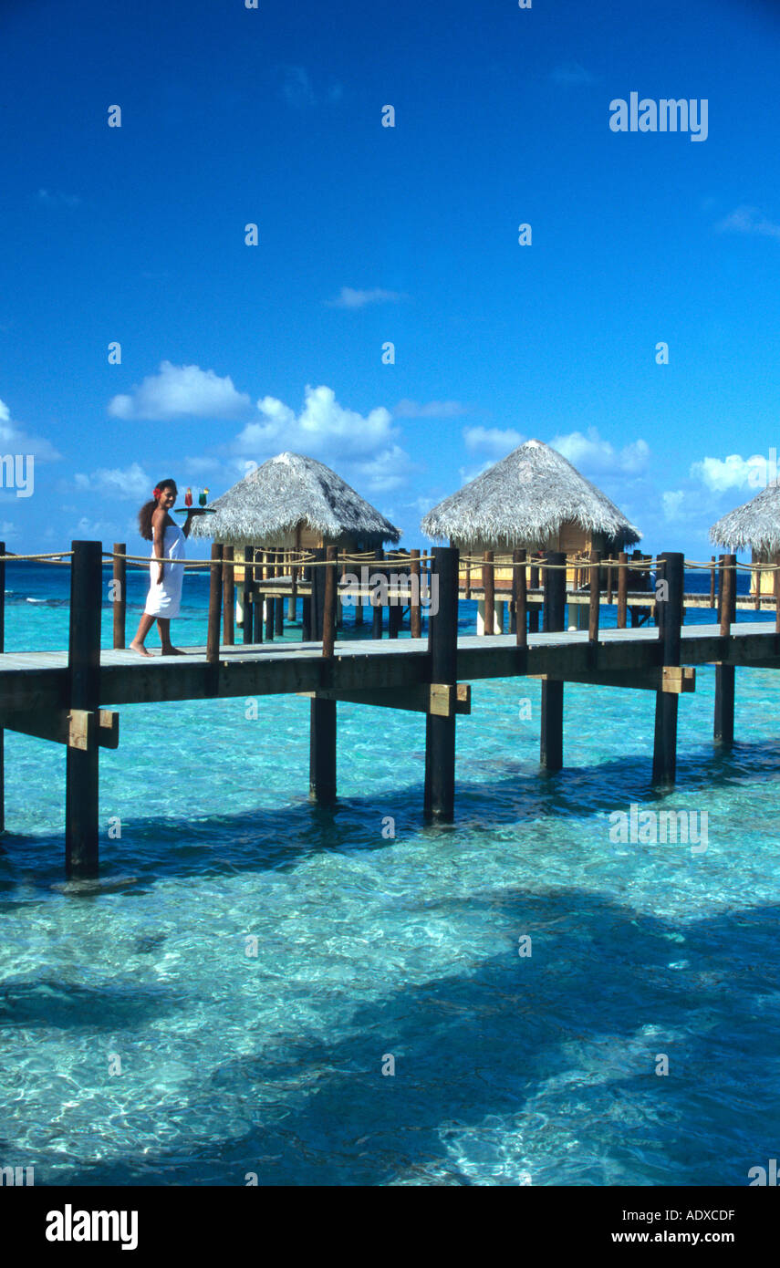 Piuttosto giovane cameriera portare bevande in un bungalow sull'acqua a Manihi Beach Hotel ,Tahiti Foto Stock