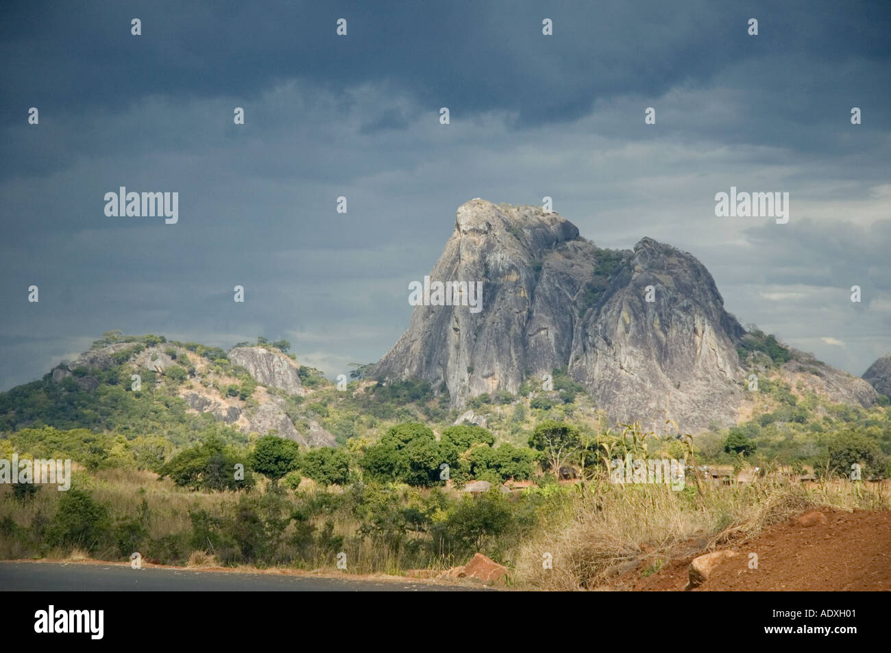 In Mozambico la roccia delle montagne che si profila contro un buio cielo nero nella savana africana Foto Stock