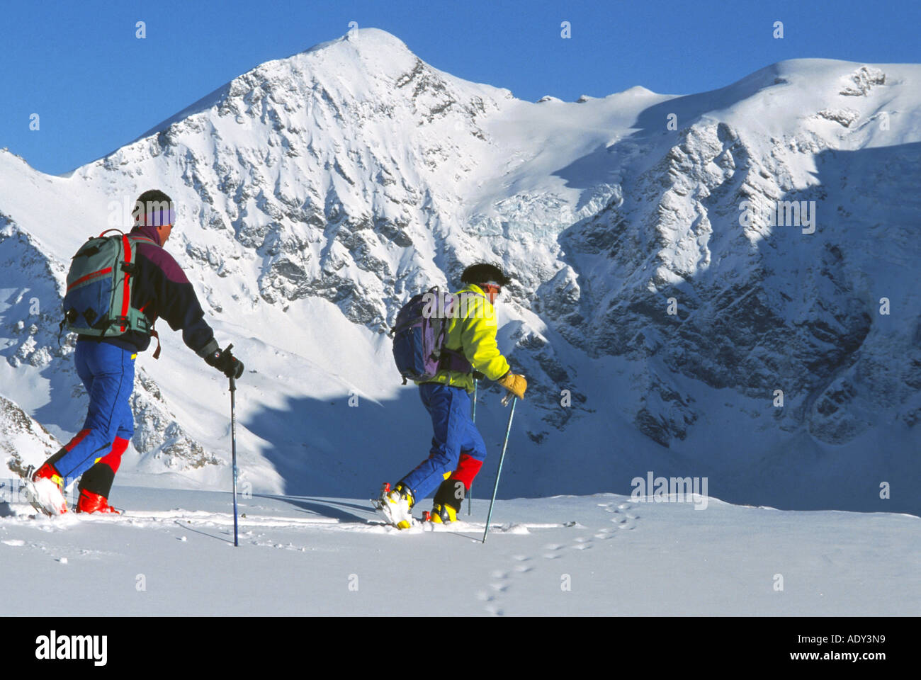 Persone che fanno la alpine ski tour, con snow-capped mountain in background Foto Stock
