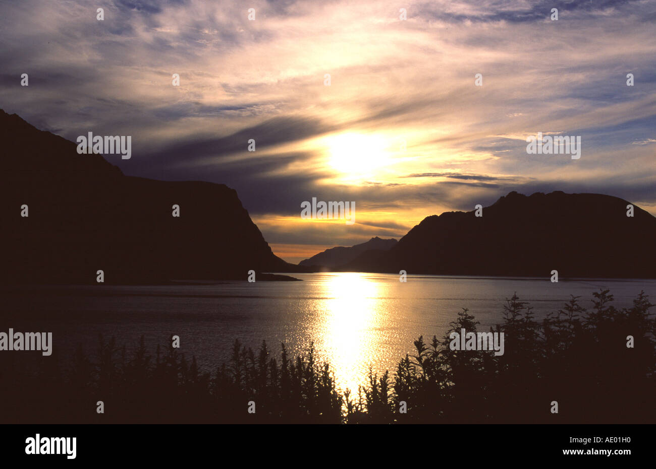 Mitternachtssonne und Berge spiegeln sich im Fjord Norway Foto Stock