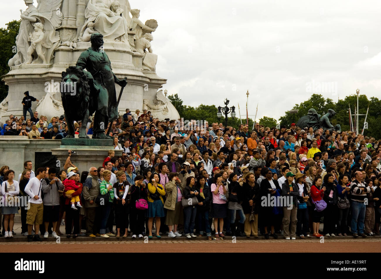 La folla di turisti in piedi vicino al Queen Victoria Memorial fuori Buckingham palace Foto Stock