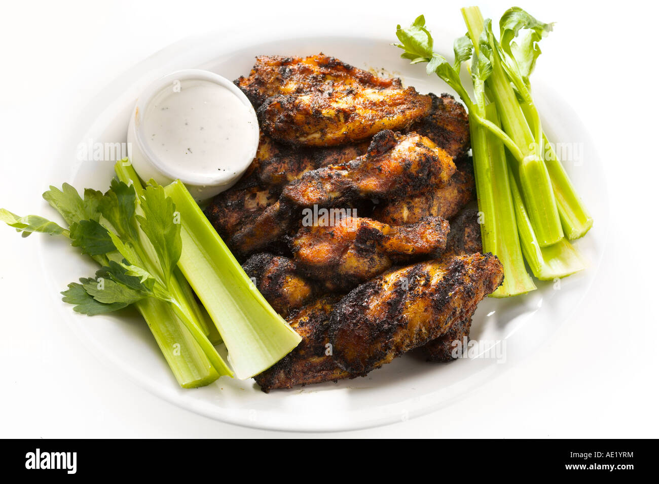 Buffalo annerito le ali di pollo su una piastra bianca con sedano celeries e ranch dressing Foto Stock