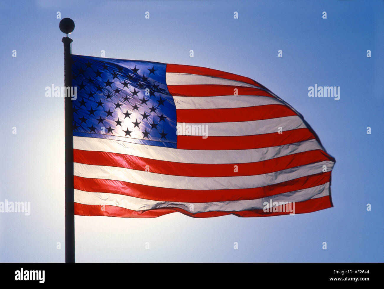 Sole che splende dietro la bandiera americana Foto Stock