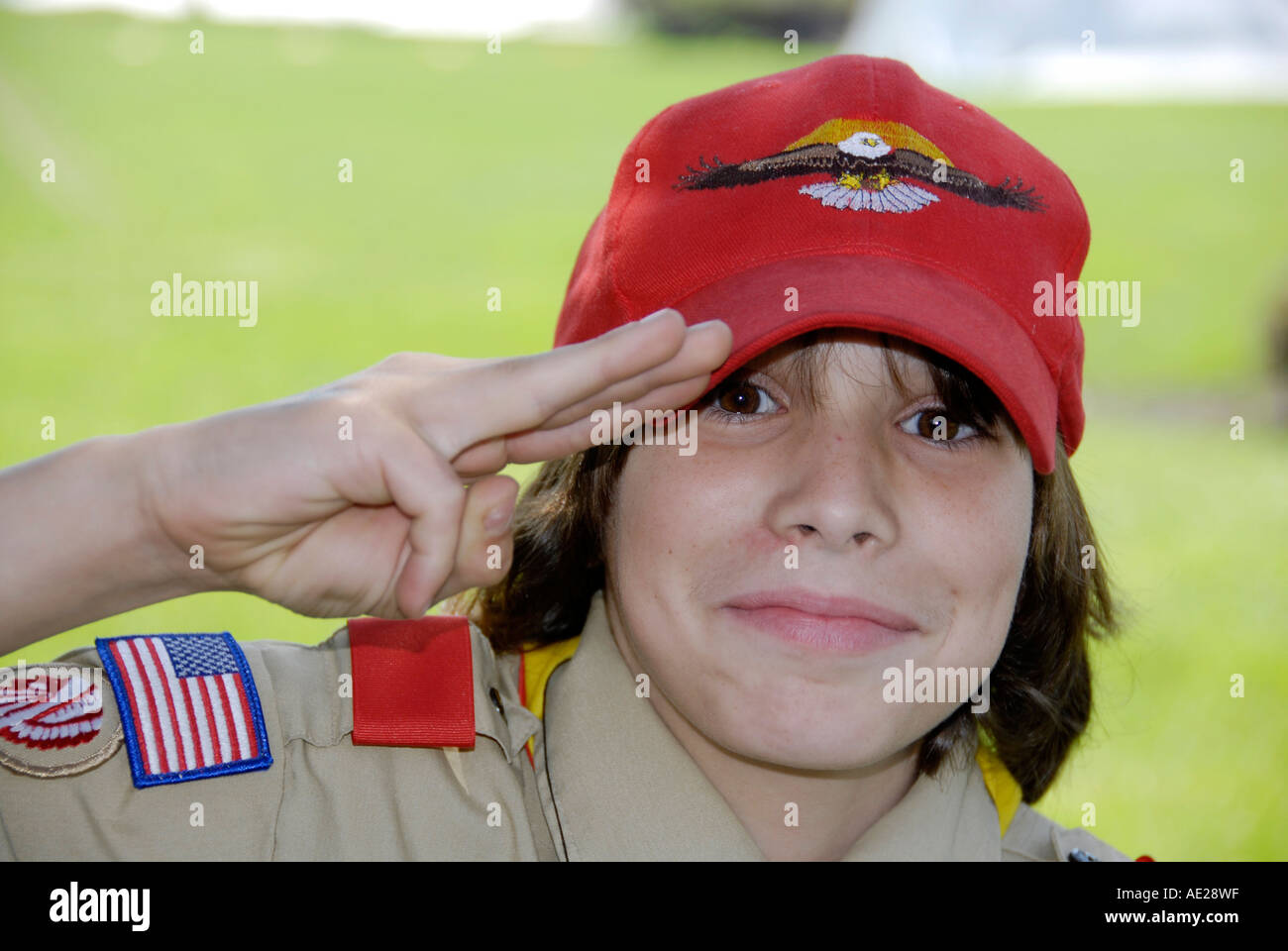 Boy Scout in uniforme esegue con tre dita in omaggio Foto Stock