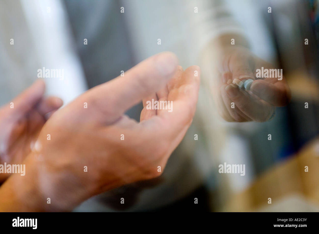 Un uomo che trattiene la sua mano per due pillole. Foto Stock