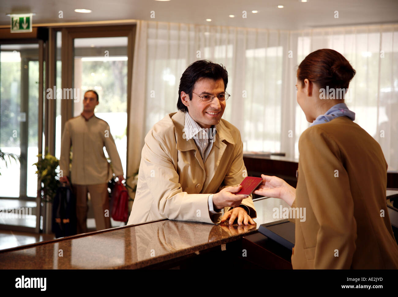 L'uomo il check in presso la reception dell'hotel Foto Stock
