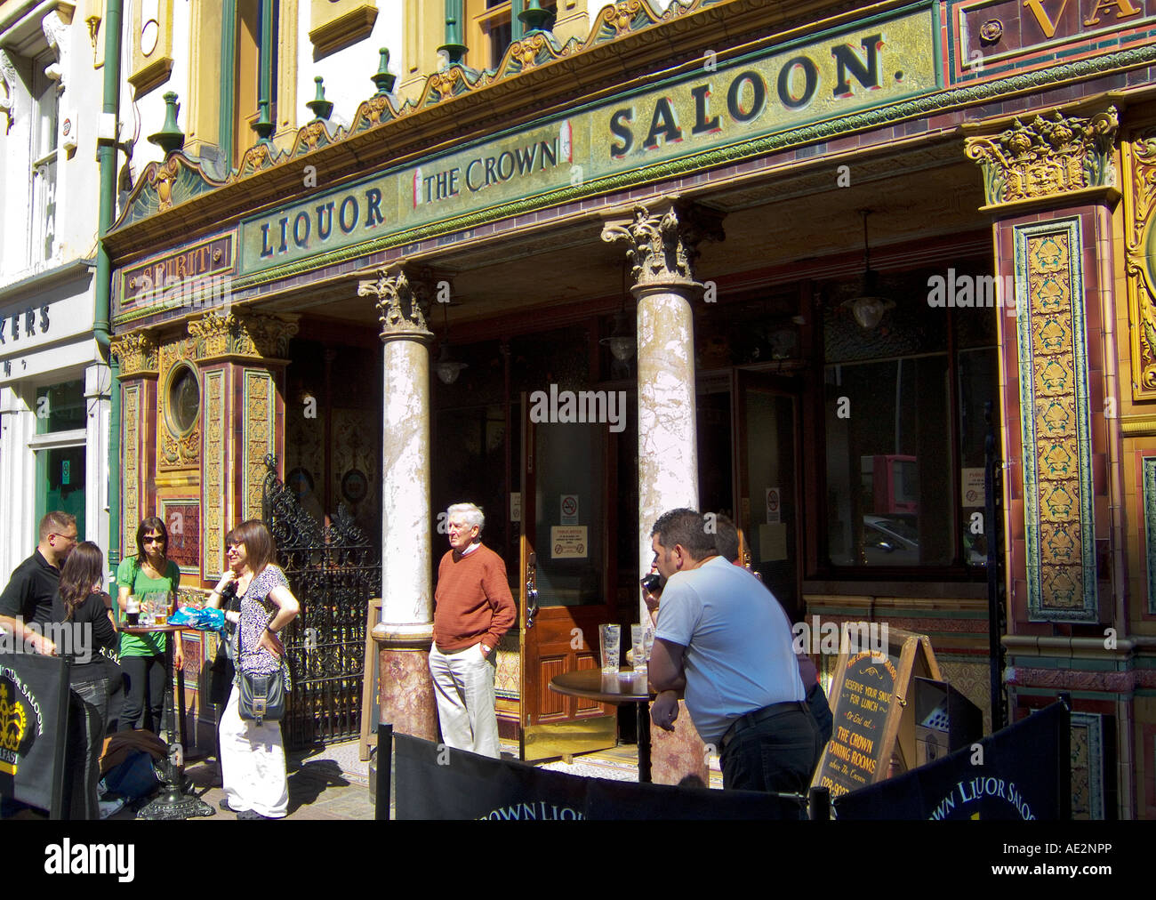 Persone che bevono al Crown Bar, Great Victoria Street, Belfast, Irlanda del Nord. Scena di pub Street. Un punto di riferimento della città Foto Stock