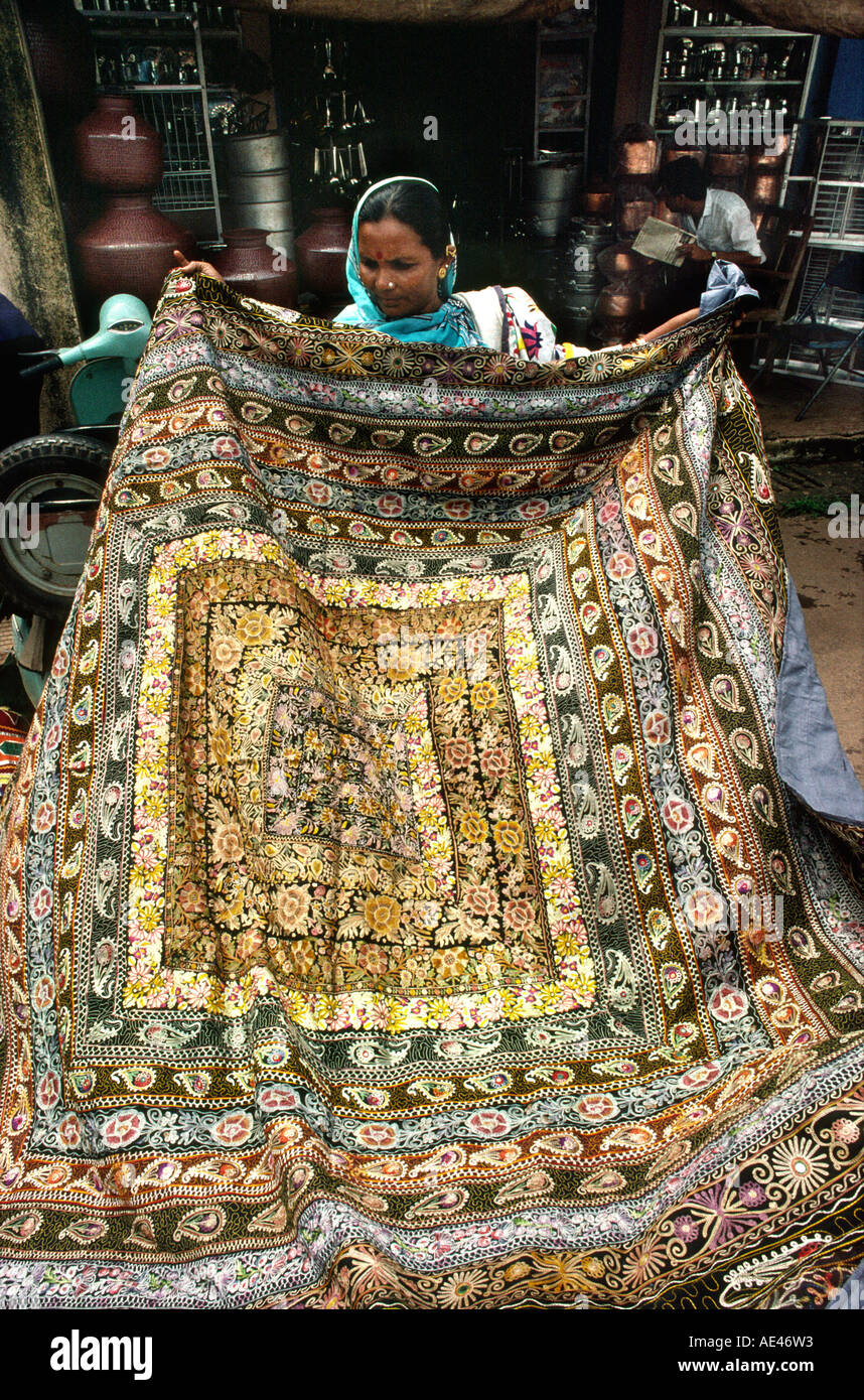 India Goa mercato Mapusa artigianato donna guardando tessili ricamati Foto Stock