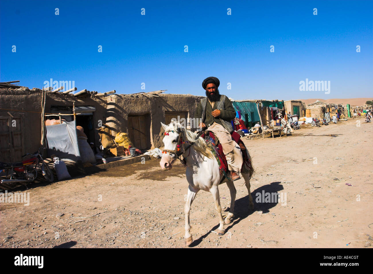 Uomo a cavallo lungo la strada nel piccolo villaggio, tra Herat e Maimana, dopo Bala Murghah, Afghanistan, Asia Foto Stock