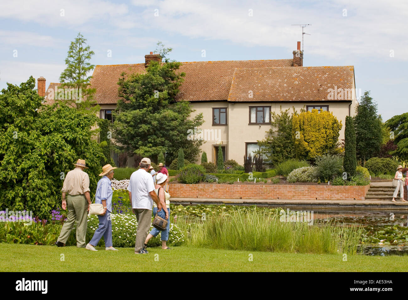 I VISITATORI DI RHS Garden HYDE HALL, vicino a Chelmsford, a piedi nella parte anteriore della vecchia casa colonica che ospita la Biblioteca del giardino Foto Stock