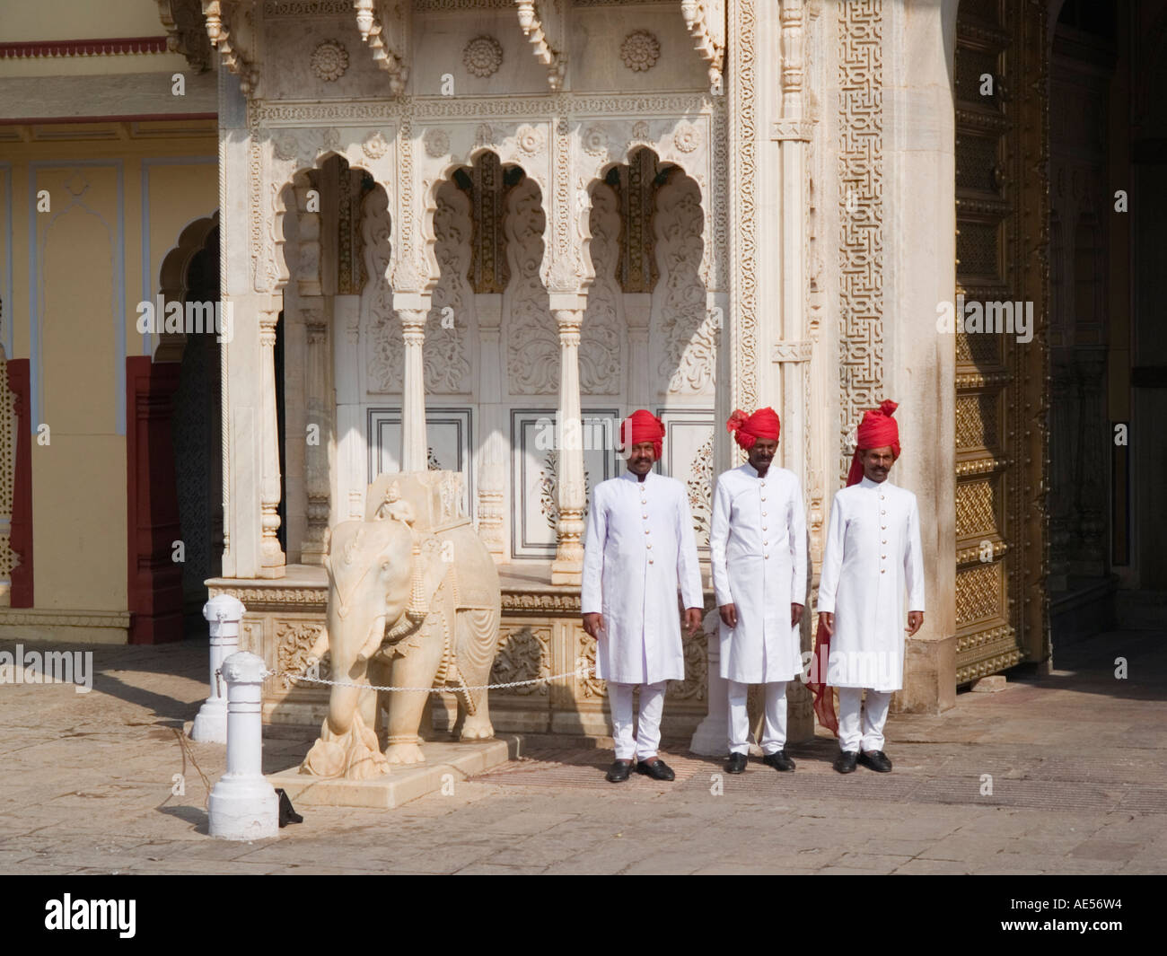 La città di Jaipur Palace - tre soldati di guardia in piedi indossando smart bianco uniforme con turbante rosso nella città Palace courtyard India Foto Stock