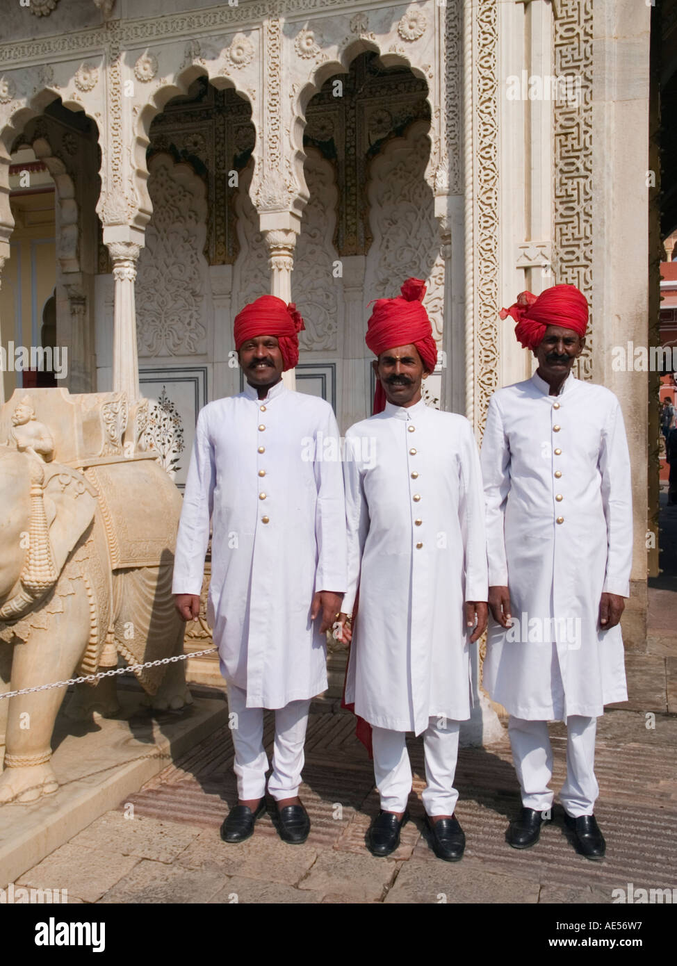 La città di Jaipur Palace - tre soldati di guardia in piedi indossando smart bianco uniforme con turbante rosso nella città sul cortile del palazzo Foto Stock