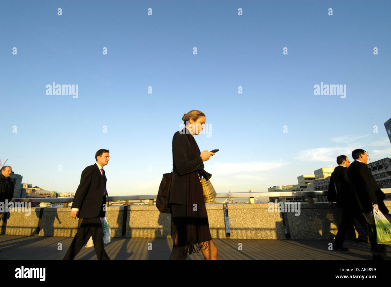 Ufficio città di lavoratori attraversando il Ponte di Londra, in Inghilterra, Regno Unito Foto Stock